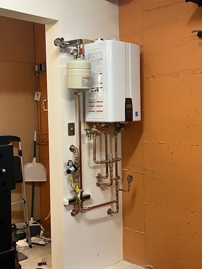 Plumbing technician inspecting water heater connections in La Joya